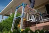 A person is using a work platform on the steps of a house. Anteprima dell’immagine prodotto