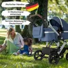 A woman and child are sitting on grass in a park next to a baby stroller. Produktbild-Vorschau
