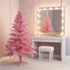 A pink artificial Christmas tree is set up in a room with a vanity table and mirror. Produktbild-Vorschau