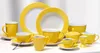 A collection of yellow and white ceramic tableware, including plates, cups, and a sugar bowl, arranged on a white surface. Produktbild-Vorschau