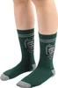A pair of green socks with a Slytherin emblem is shown on a person's legs. Produktbild-Vorschau