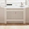 A white radiator cover with horizontal slats is placed in front of a window. Náhľad obrázku produktu