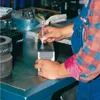 A person is using a marker to mark a metal object on a workbench in a workshop. Produktbild-Vorschau