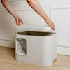 A person's hands are shown lifting the lid off a modern, white cat litter box. Voir les images du produit