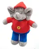 A plush toy elephant wearing a red shirt and blue pants, with a red hat on its head. Produktbild-Vorschau
