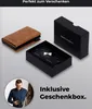 A brown cardholder and its black gift box are displayed on a light gray background, with a man in the lower left corner. Produktbild-Vorschau