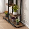 A multi-tiered plant stand with various potted plants on a wooden floor. Náhled obrázku produktu