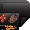 A collage showing multiple black grill mats, with one mat in the foreground displaying grilled steak, tomatoes, and skewers. Produktbild-Vorschau