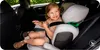 A young girl is sitting in a car seat in the back seat of a car. Anteprima dell’immagine prodotto