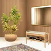 A shoe rack with a bench and cushion, placed next to a potted plant, with a mirror on the wall. Produktbild-Vorschau