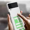 A person's hands are holding a white Samsung Galaxy Z Flip 3 phone case with a green sticker on it. Produktbild-Vorschau