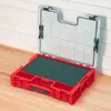 An open red organizer box with a clear lid, placed on a wooden surface against a white wooden wall. Anteprima dell’immagine prodotto