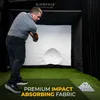 A man is playing golf indoors in a SimSpace golf enclosure, with a large screen in front of him and golf balls on a tray to the side. Produktbild-Vorschau