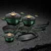 A set of cookware arranged on a dark, textured surface. Produktbild-Vorschau