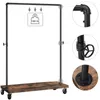 A freestanding industrial-style garment rack with a wooden shelf and wheels. Náhled obrázku produktu