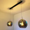 Two pendant lights hanging from a ceiling track. Voir les images du produit