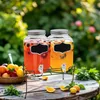 Two beverage dispensers filled with fruit-infused drinks on a wooden table outdoors, with a basket of fruit and greenery in the background. Náhľad obrázku produktu