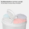 Close-up of the top of a white storage container with four petal-shaped lids in different pastel colors. Produktbild-Vorschau
