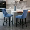 Two blue velvet bar stools in a modern kitchen setting.