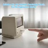 A hand is inserting a floppy disk into a vintage-style computer that is likely a desk clock or alarm. Produktbild-Vorschau