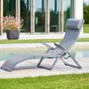 A gray lounge chair is placed on a patio next to a swimming pool, with a modern house in the background. Produktbild-Vorschau