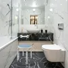 A modern, marble-tiled bathroom with a bathtub, sink, toilet, and a shower stool with a grab bar. Náhľad obrázku produktu