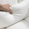 A hand is pressing into a white cushion, likely demonstrating its softness or material. Podgląd zdjęcia produktu