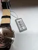A close-up of a watch tag and part of a watch. Produktbild-Vorschau