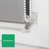 A close-up view of a roller blind mechanism, showing the chain and its holder attached to a white frame. Produktbild-Vorschau