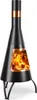 A black outdoor fireplace with copper accents and flames visible inside, standing on a white background. Produktbild-Vorschau