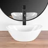 A white oval vessel sink with a black faucet is shown on a wooden surface, with a mirror reflecting the sink and faucet in the background. Náhled obrázku produktu