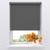 A grey roller blind is shown covering most of a window, with a vase of orange tulips on the windowsill below. Produktbild-Vorschau