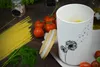A white porcelain storage jar with a dandelion design is placed on a wooden table next to spaghetti, tomatoes, and dill. Produktbild-Vorschau