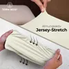 A split image showing a hand stretching a cream-colored fabric and another hand holding a gathered section of the same fabric, with arrows indicating airflow. Produktbild-Vorschau