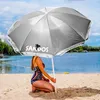 A person sitting on a beach under a large umbrella. Náhled obrázku produktu