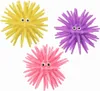 Three spiky, colorful toys with googly eyes arranged on a white background. Produktbild-Vorschau