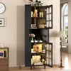 A tall, black cabinet with glass doors filled with decorative items, placed in a room with a clock on the wall and a floor lamp nearby. Anteprima dell’immagine prodotto