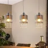 Three pendant lights hanging over a dining table with a plant and decorative bottles in the foreground. Anteprima dell’immagine prodotto