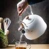 A hand is pouring hot water from a white kettle into a clear glass mug, with steam rising. Podgląd zdjęcia produktu