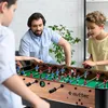A father and his two sons are playing foosball in a living room. Náhľad obrázku produktu