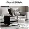 A modern coffee table is placed in a living room setting in front of a sofa. Produktbild-Vorschau