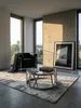 Moderner Couchtisch aus Edelstahl und schwarzem Glas in einem minimalistischen Wohnzimmer mit großformatigen Kalksteinplatten und bodentiefen Fenstern._#sku_SAFWL6.674# Produktbild-Vorschau