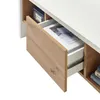 A close-up view of an open drawer in a piece of furniture, revealing storage space and some items inside. Produktbild-Vorschau