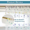 A close-up view of a sheer curtain with pom-pom decorations, showing how it attaches to a curtain rod. Produktbild-Vorschau