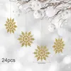 Gold glitter snowflakes and white Christmas ornaments hang from a branch against a blurred snowy background. Náhľad obrázku produktu