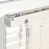 A close-up view of the top mechanism and hanging cords of a cream-colored blind. Produktbild-Vorschau