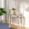 A mirrored console table with a mirror above it, decorated with books, a vase with flowers, and a decorative object, next to a floor lamp and a potted plant. Produktbild-Vorschau