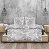 A bed with grey and white floral patterned bedding in a room with a concrete wall and wooden floor. Produktbild-Vorschau