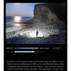 A person standing on a rocky beach at night, illuminated by a powerful flashlight. Produktbild-Vorschau