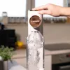 A hand is shown pressing the top of a Wessper water carbonator as it carbonates water in a bottle. Produktbild-Vorschau